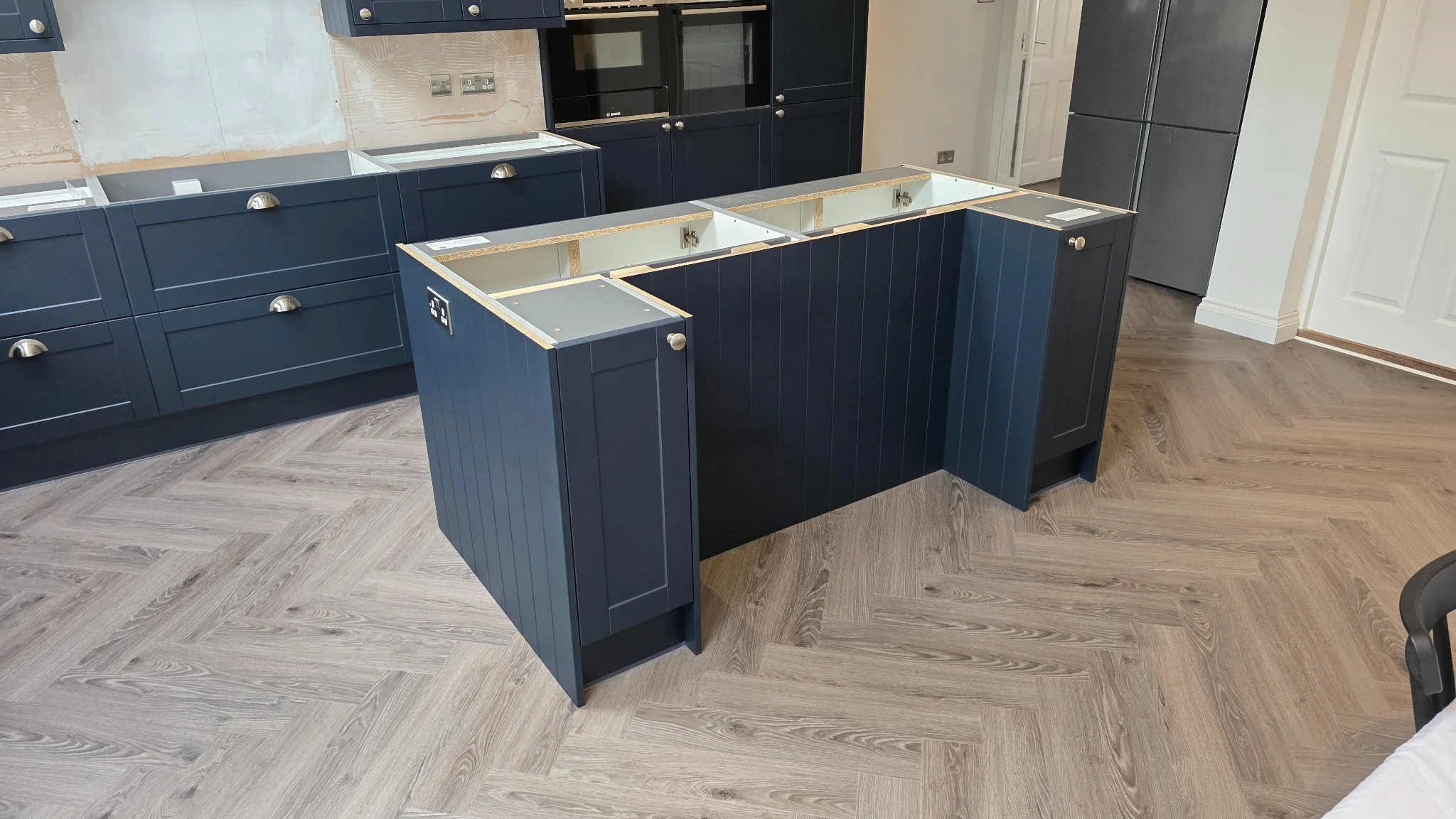 Kitchen island and patterned flooring during a kitchen installation